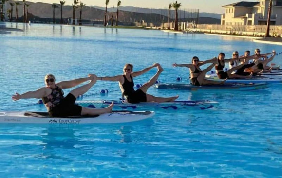 people posing on paddle boards in the lagoon of a St. George vacation rental