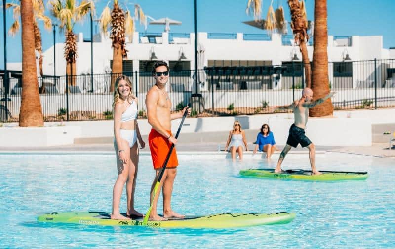 couple posing on a paddle board at Desert Color Resort in St. George